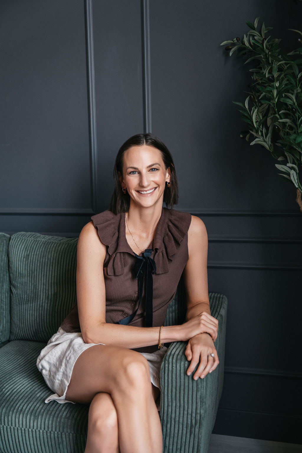 Kyshel seated beside an olive plant